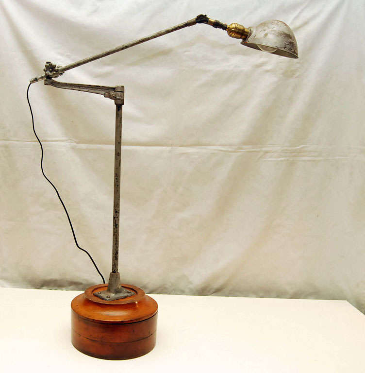 Industrial lamp, by O.C. White, of Worcester Mass. Adjustable, articulated arm extends with a wide range of movement with ease.  Mounted on a period wooden factory mold.