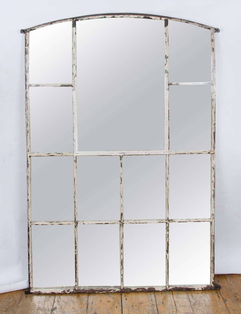This impressive mirror is made from a reclaimed antique warehouse window mirror that was removed from a Victorian warehouse in Kentish Town, north London. The cast iron frame has a charming weathered appearance, with layers of paint adding to the