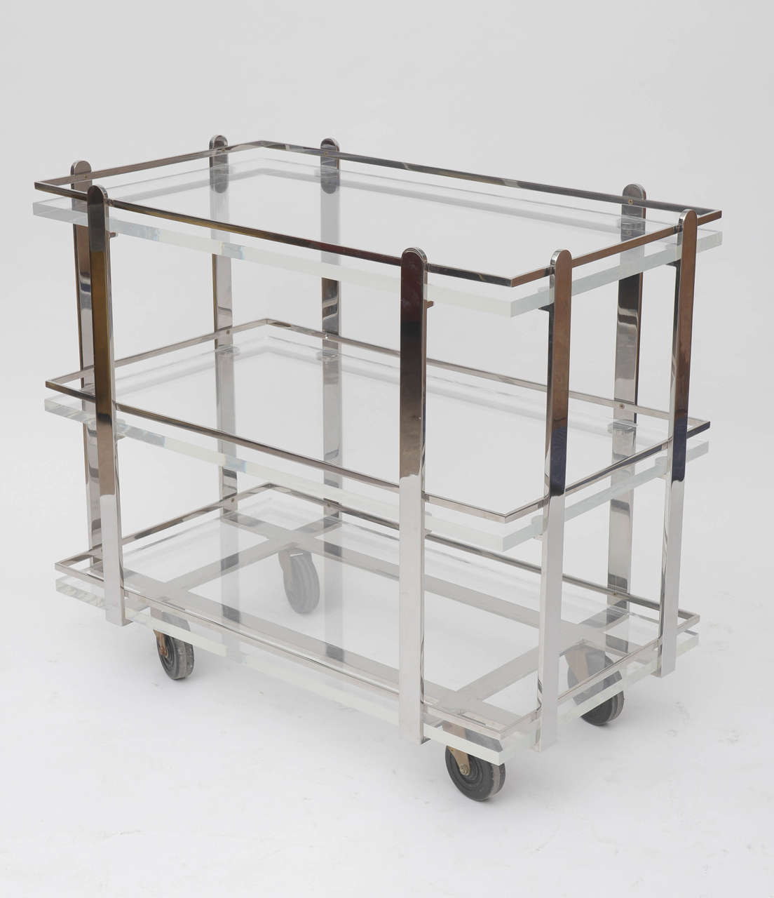 A rarely seen form by Karl Springer.
The cart has a mirror polished steel frame enclosing three thick Lucite shelves.