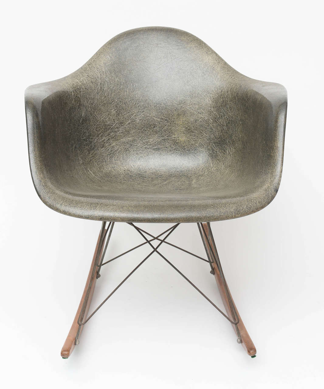 This is a first edition rocker, featuring front struts that connect to the back legs and a great elephant hide grey shell.