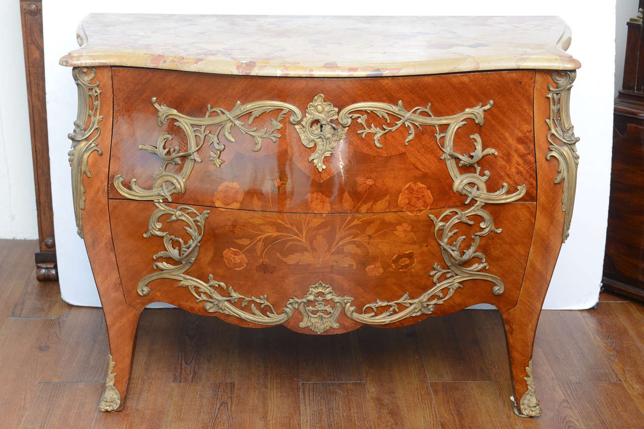 Well crafted by an excellent craftsman, this French commode has every details as the original period antiques at a fraction of the price. The beautifully executed marquetry is enhanced by the fine casted ormolu mountings on both the front and sides.