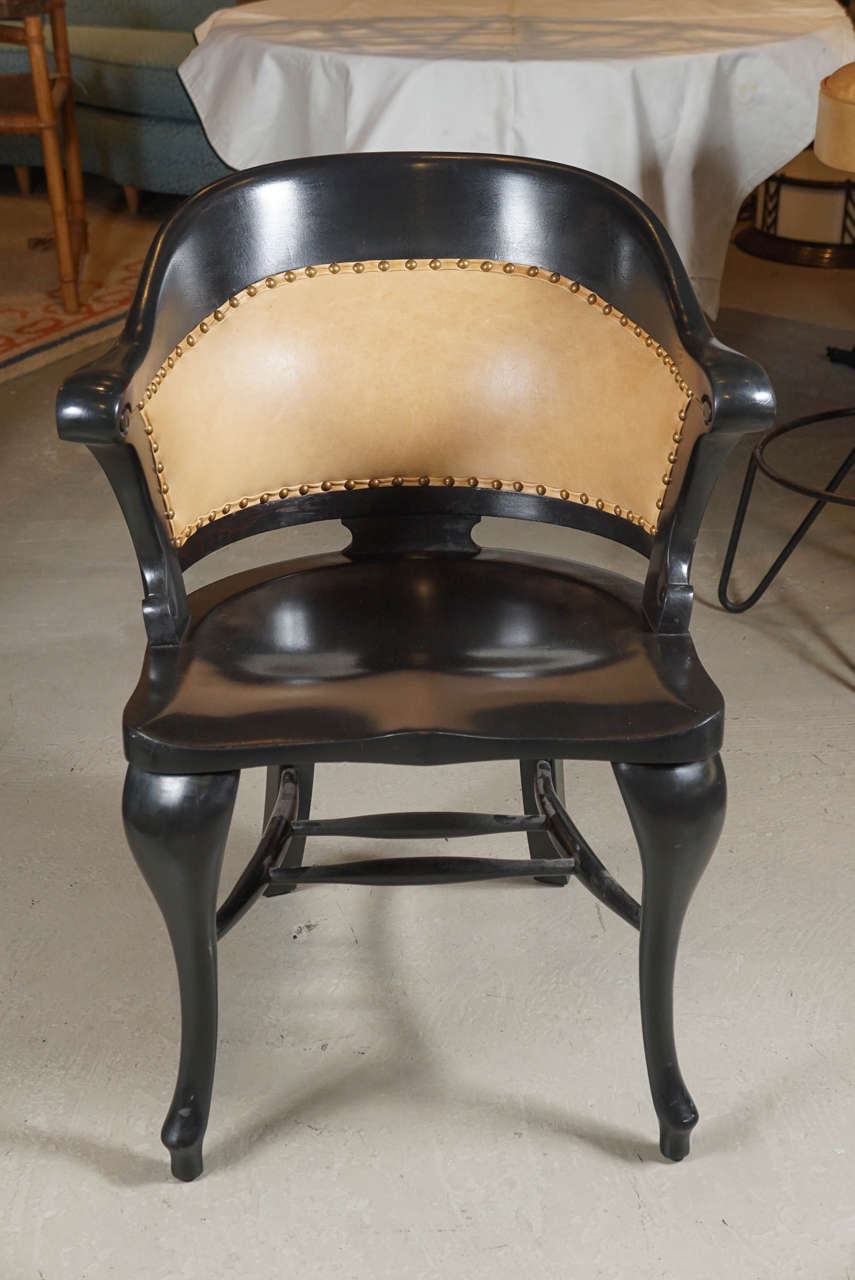 This solid mahogany schoolhouse chair has fantastic and unusual form. Recently upholstered in brass studded leather. Dynamic form and contour as well as comfort make this a perfect desk or office chair.