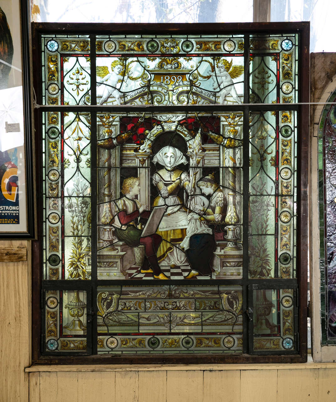 This antique, reversed painted, stained glass window is dated 1892. It is a true piece of art. Magnificent background with scroll floral design. It is a masterpiece! Gold leaf acanthus and leaf columns with golden lilies adorn the background. 26