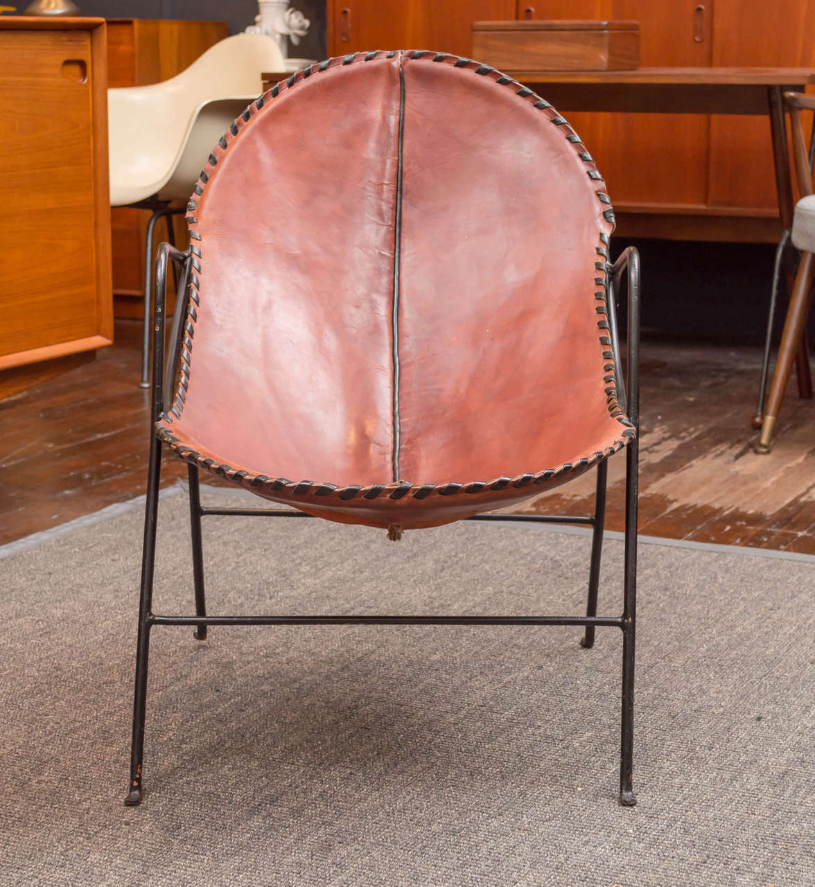 Bohemian chic pair of leather and wrought-iron frame lounge chairs. 
One chair has an age appropriate margarita stain on the seat, good times!