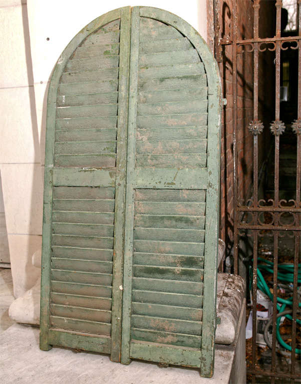 A pair of arch top French wooden shutters for a small window. Distressed paint. Originally marked $250.00