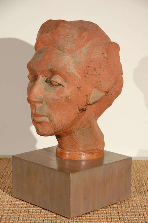 Terra cotta bust portrait of woman mounted on a wooden base stained grey.