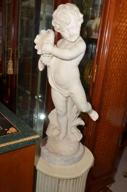Beautifully carved Italian Carrera marble cherub statue holding a conch shell