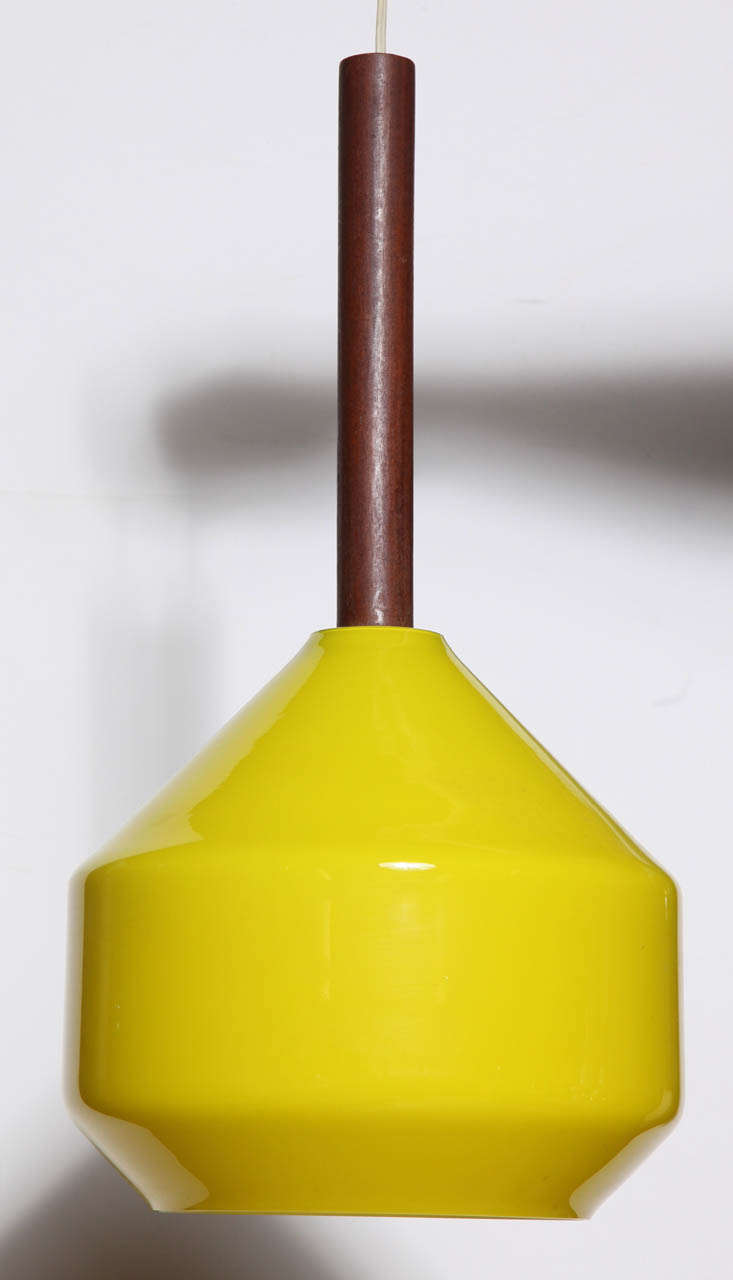 1950's Tapio Wirkkala Scandinavian Modern Lemon Yellow Cased Glass Hanging Lamp.  Featuring rounded and angular Yellow cased Glass exterior, White interior, suspended from a solid round teak center column.  Beautiful when illuminated. Vibrant. Made