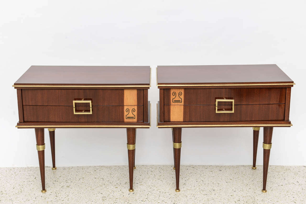 The rectangular top with a bronze frieze, above two drawers with geometric inlay, on round tapering legs with bronze mounts.