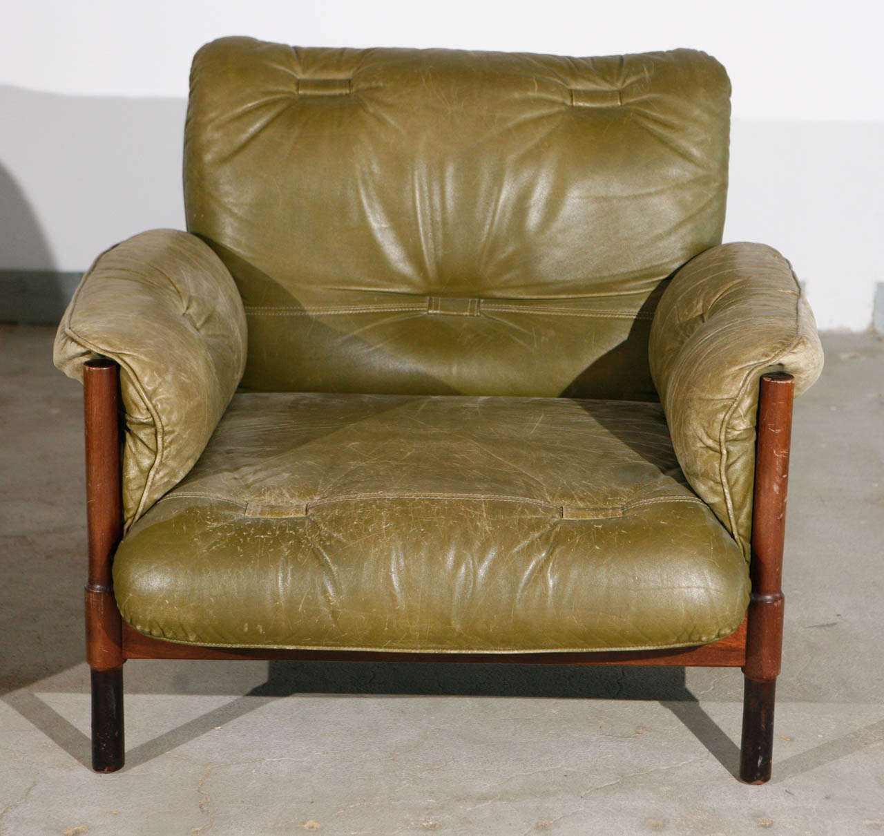 Pair of Brazilian green leather and wood armchairs with green leather strapping and quilting.