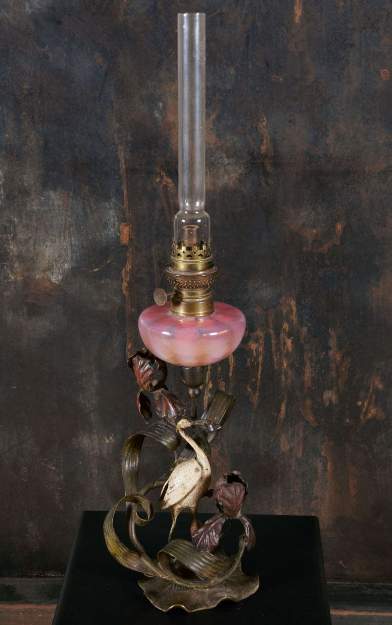 19th Century oil table lamp. French work. Bronze and steel with polychrome patina and with a pink opalescent glass reservoir.
Height without the tube: 16.14
