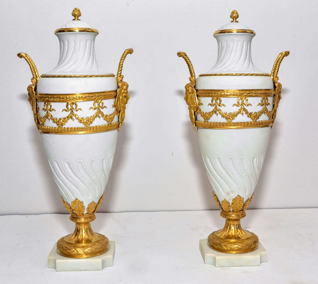 pair of  white porcelain bisquit urns, orned with decoratives gilded  bronzes
with amovible tops