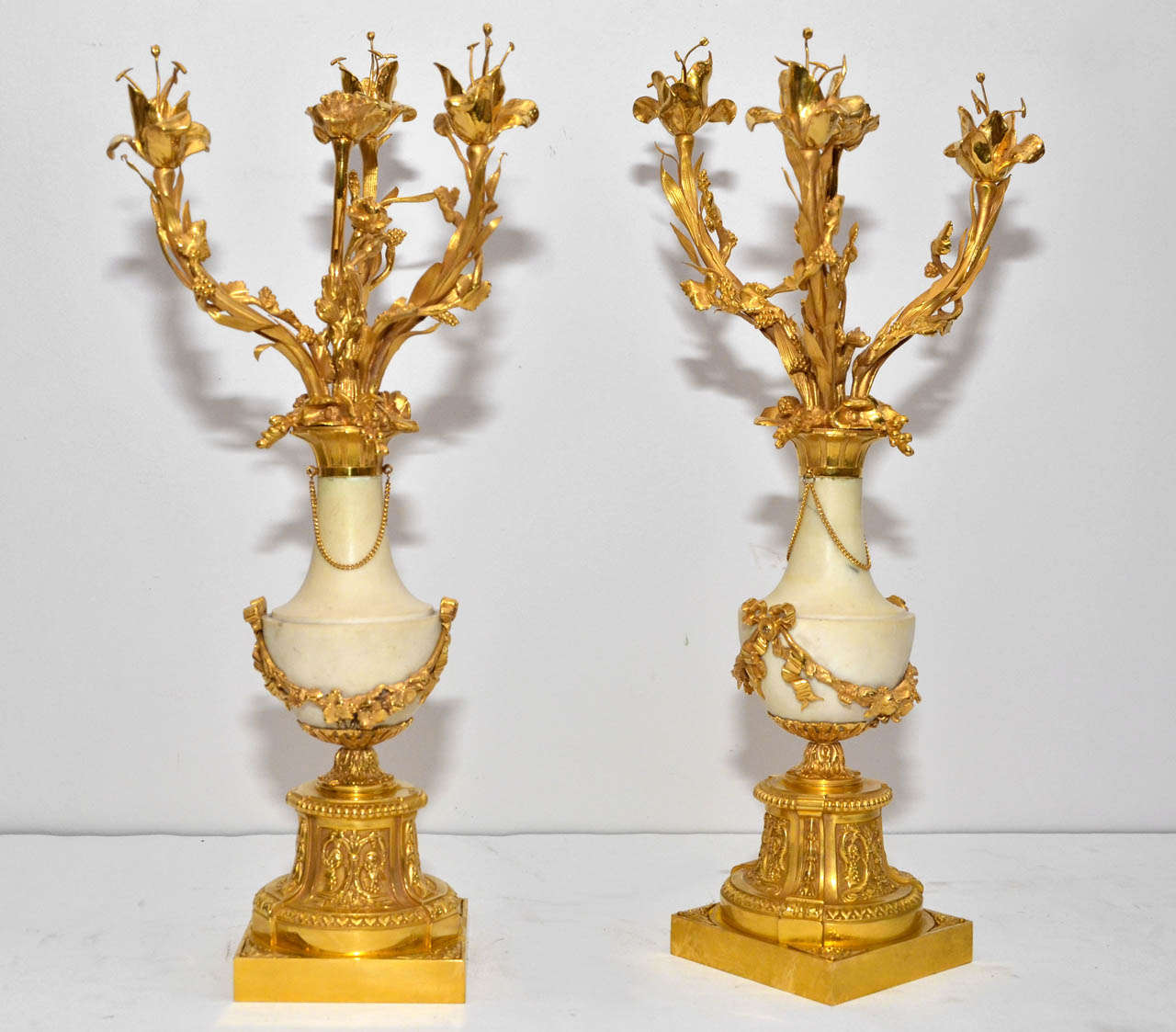 gorgeous pair of candalabras, marble vases holding 4 arms of lights.
Vases resting on gilded bronze base