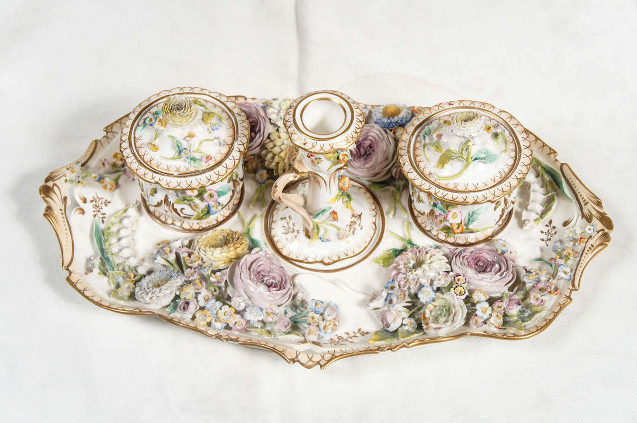 Minton “Triple Bucket” inkstand, circa 1830, the chamfered rectangular tray with gilt twig handles at the ends issuing white applied floral sprays, the center three depressions fitted with small covered buckets, one fitted as an inkwell, another