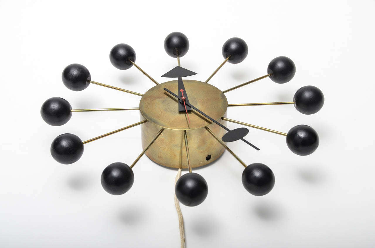Early Geoge Nelson Wall Clock with patinated Brass Face & Spokes.  All ebonized wood balls, hands and red second hand are original.   This example is a plug-in model and retains the original underwriters lab. sticker.