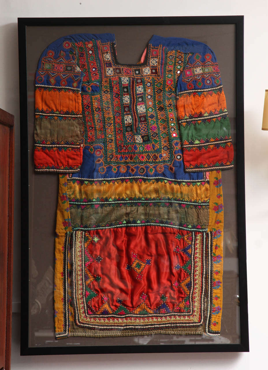 A ceremonial dress from India, with embroidered accents and sequins, framed.
