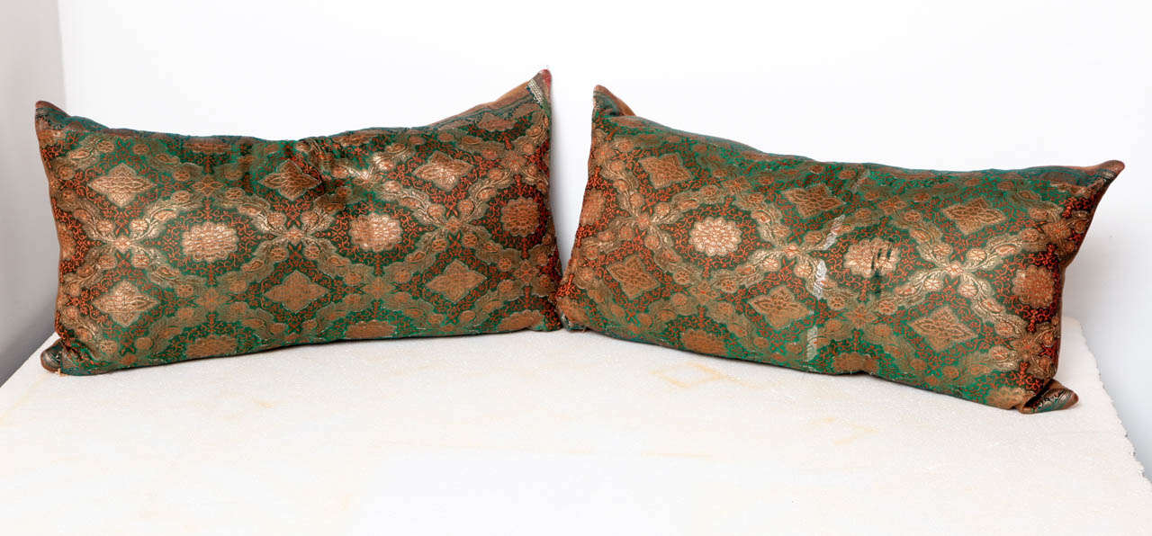An embroidered silk pillow in gold, green and persimmon. Backed with 100% wool fabric.