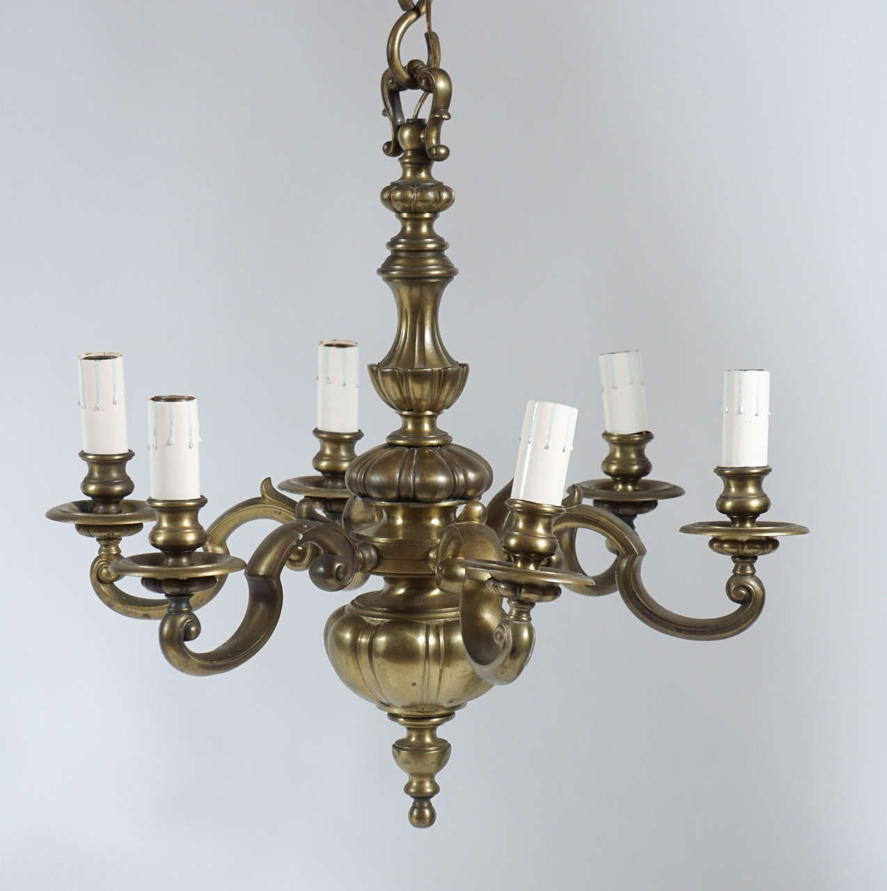 English baroque style solid bronze six light chandelier having six cusped scroll arms on gadrooned and fluted main body.  Wonderful colour and patina.  Photos show a skewed arm, however all arms can be positioned as desired as they swivel.  Body