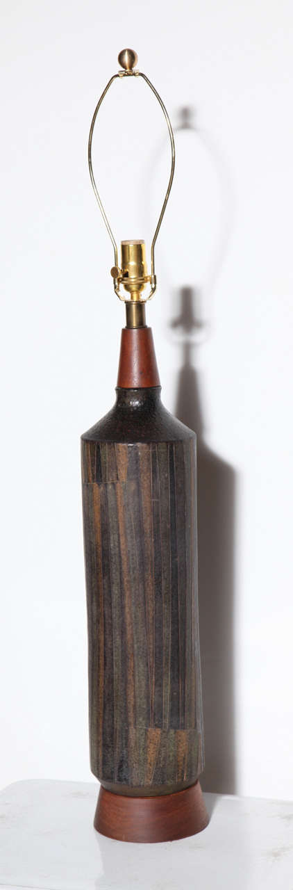 Tall, Circa 1959 Milano Moderna Aldo Londi by Bitossi for Raymor Art Pottery Table Lamp. Featuring a cylindrical bottle form with conical teak neck, turned teak base and brass detail. With Milano Moderna incised vertical, geometric, abstract design