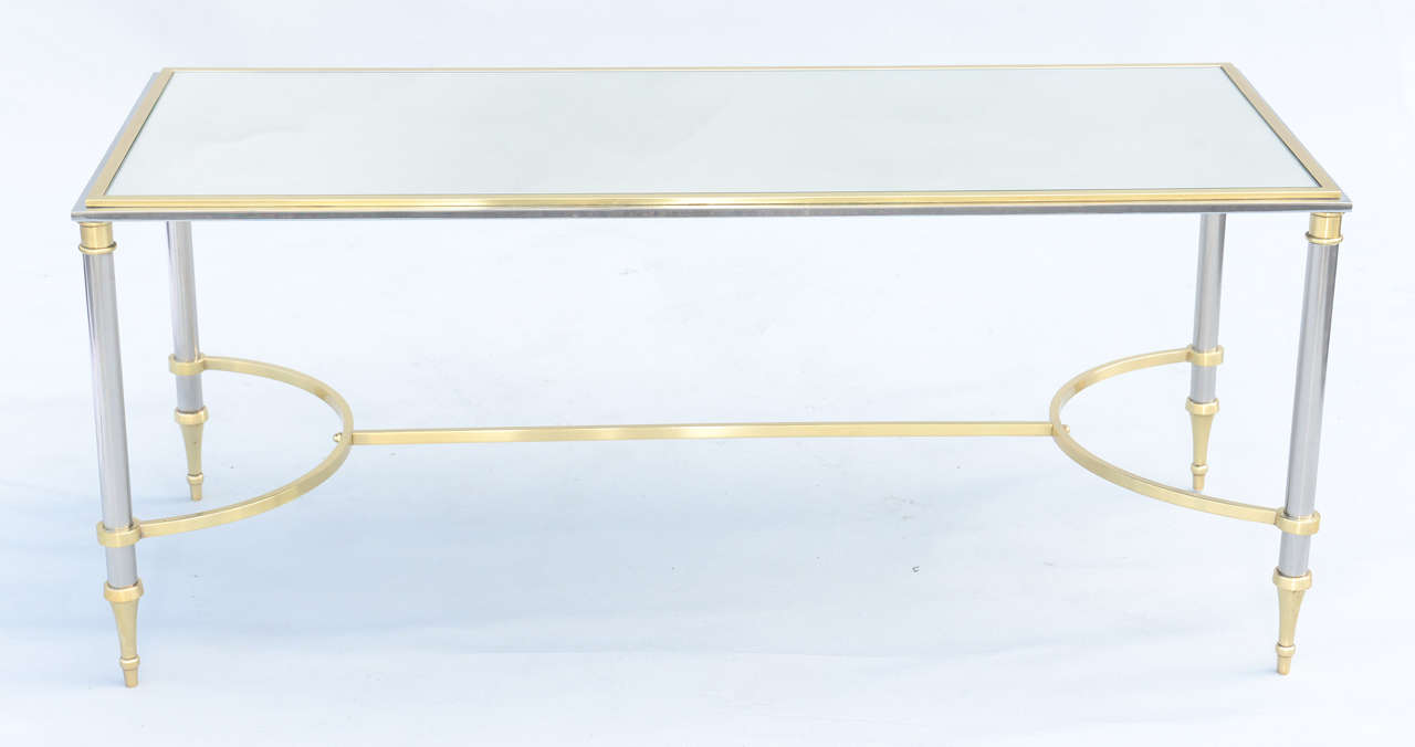 Jansen style cocktail table, having mirrored top inset in polished chrome and brass frame, raised on round chrome legs with brass details, connected by brass stretcher.

Stock ID #4548