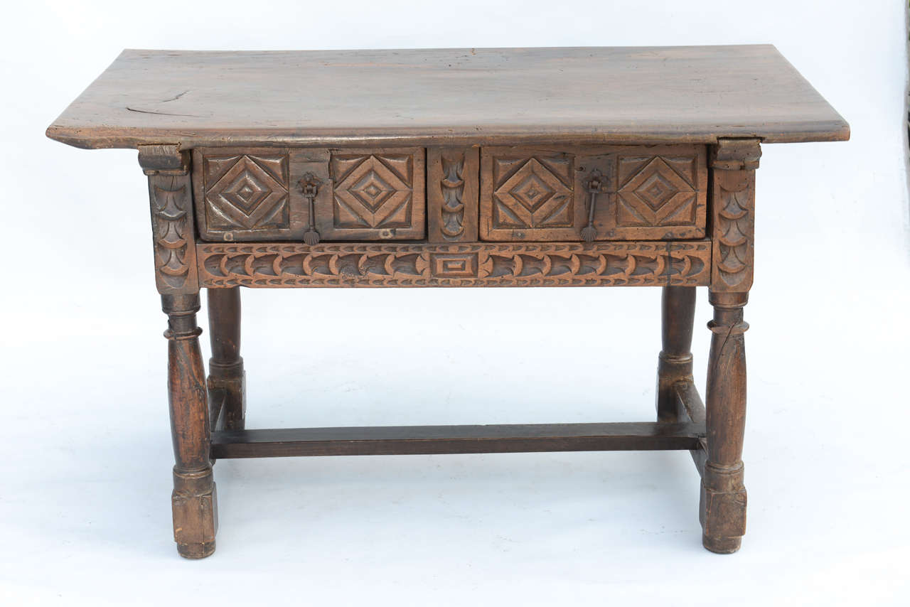 Table, of walnut, having a solid-plank rectangular top, its apron decorated by carved diamond motifs and double frieze drawers, raised on turned legs, joined by H-stretcher.

Stock ID: D9209