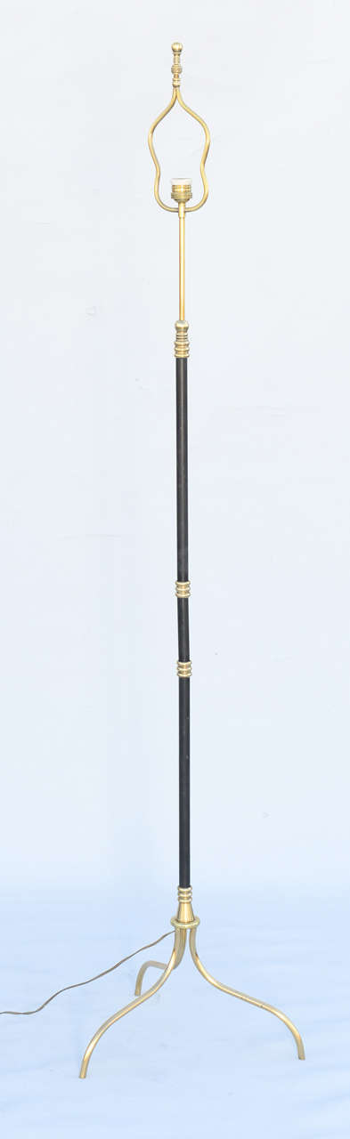 Fine floor lamp, having a tubular shaft of patinated bronze, with polished brass collars and fittings, incorporating a reeded, hour-glass-form harp, raised on splayed legs.

Stock ID: D1393