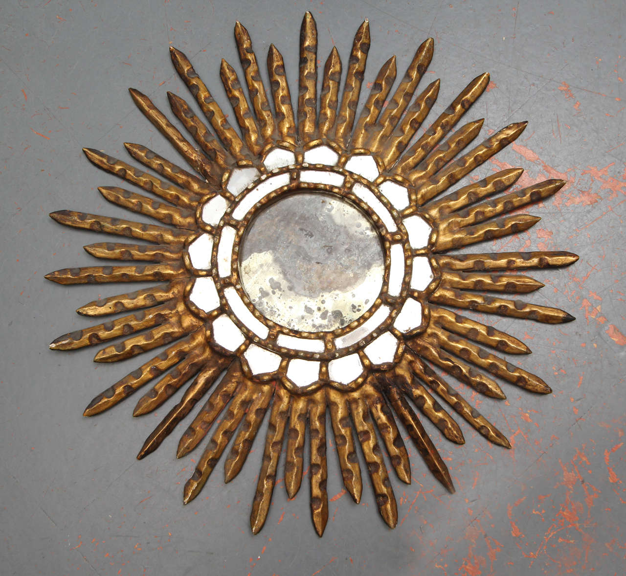 Small-scale wood gilt sunburst mirror with distressed mirror.