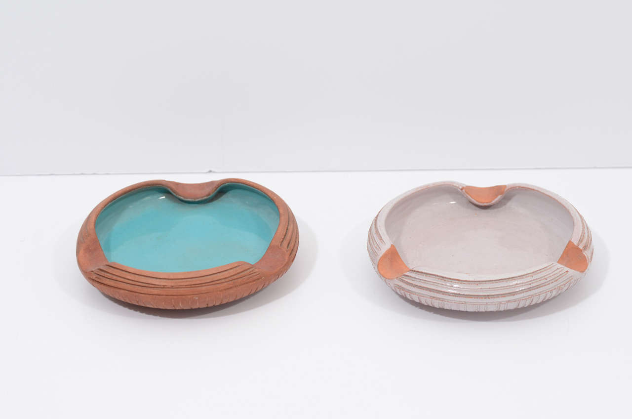 Beautiful pieces of art pottery by Urbano Zaccagnini. Incised terracotta forms, one with glazed aqua interior and the other in a pale, milky lavender. Signed en verso and priced as a pair.