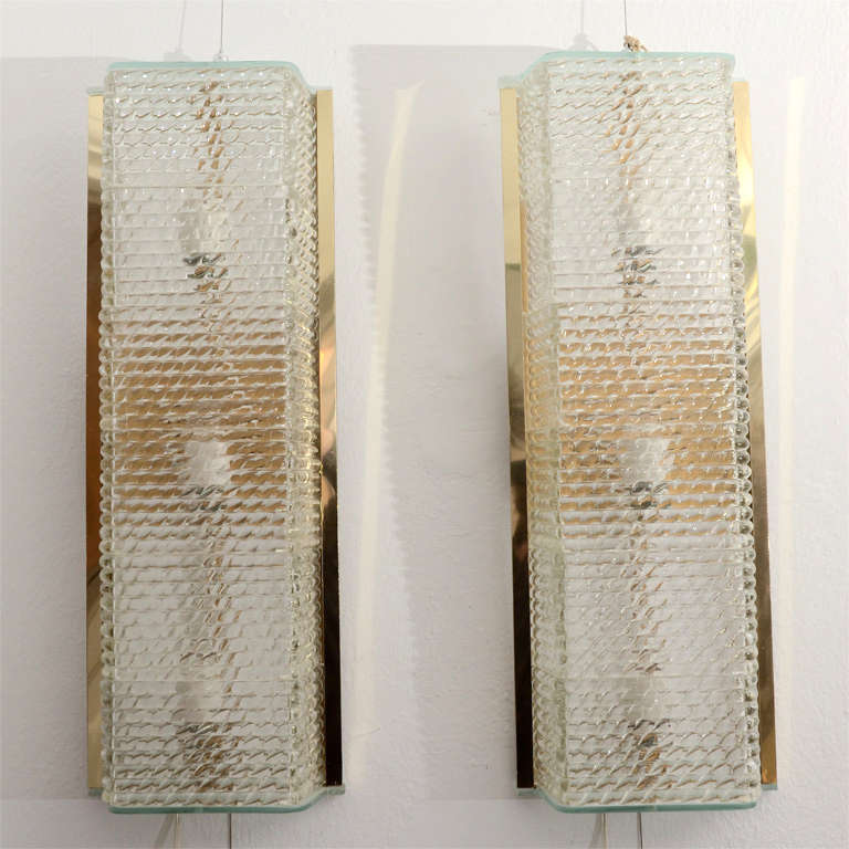 Paire d'appliques en laiton et verre texturé, chacune avec trois réceptacles Edison en céramique.