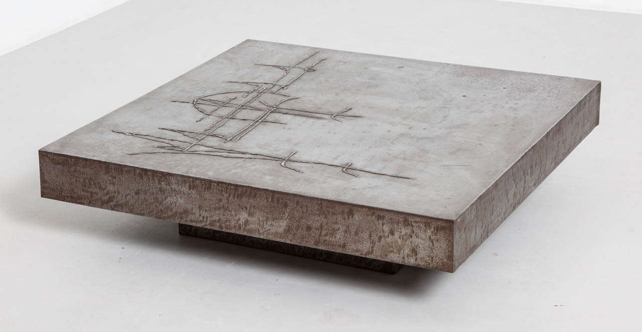 Table basse en acier moulé, probablement française ou belge des années 1960.
La partie supérieure présente une texture rugueuse.