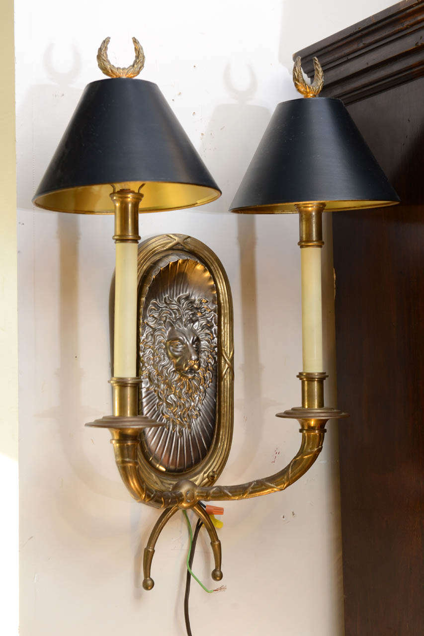 Stunning pair of two armed lion motif sconces made of brass and nickel.