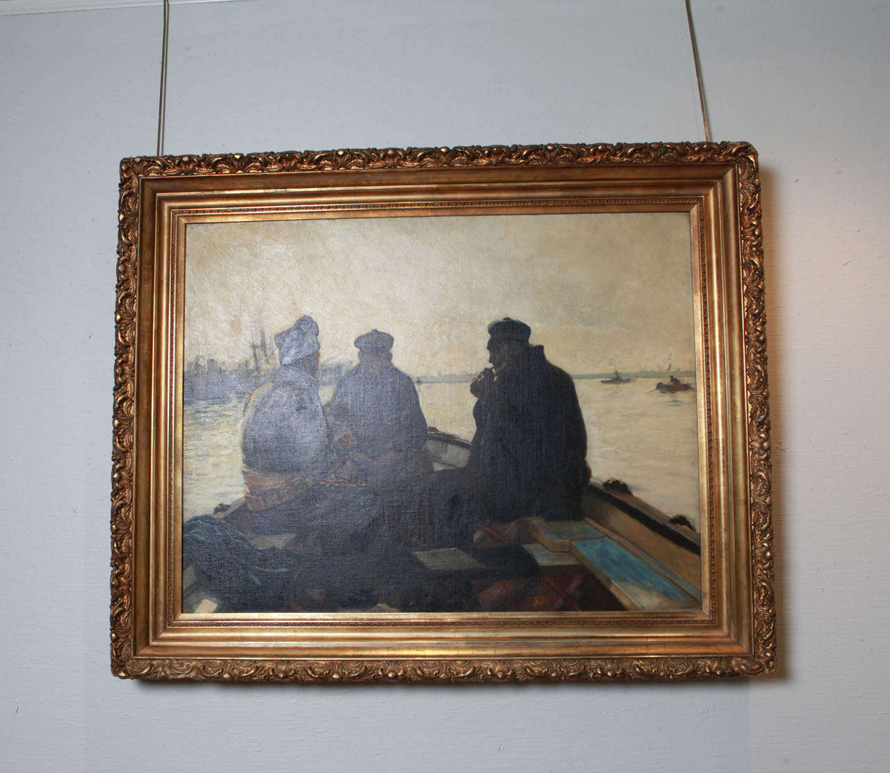 The sun is setting, a chill is in the air, as the three fishermen in this 19th century oil on canvas, discuss the success of their day and perhaps the strategy for the coming one. Beautiful period gilt carved frame. Unsigned