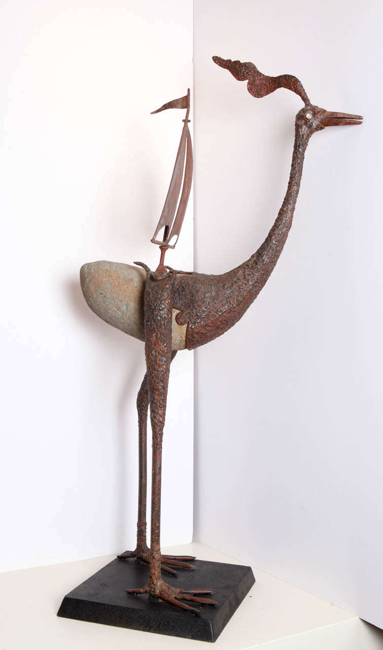 The hand hammered bird with stone body rocks to and fro from long, metal hammered bird legs created by Mexico artist, Daniel Palma. The metal sail fixed to his back as well as his rippled metal crest suggests he's about to take flight.