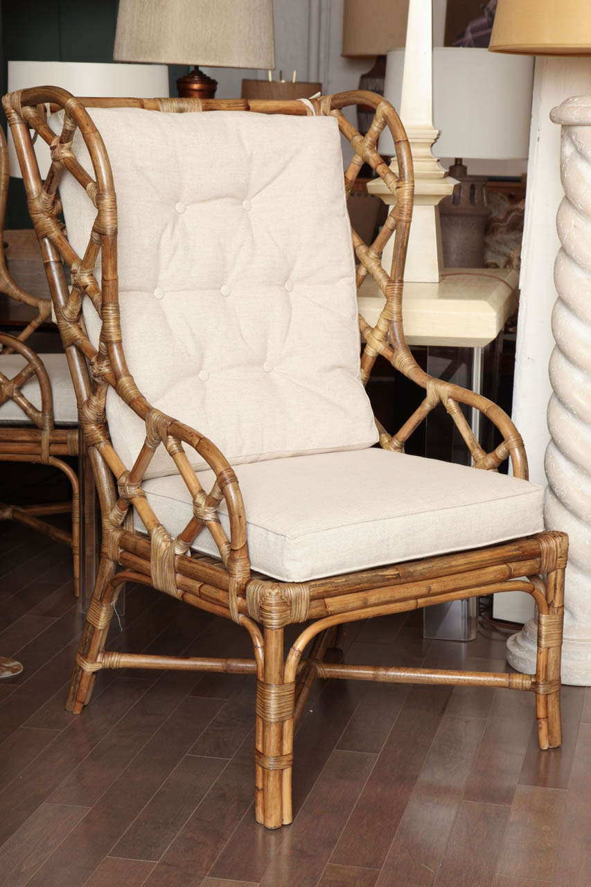 Pair of rattan wingback chairs with beige linen upholstered cushions c. 1960