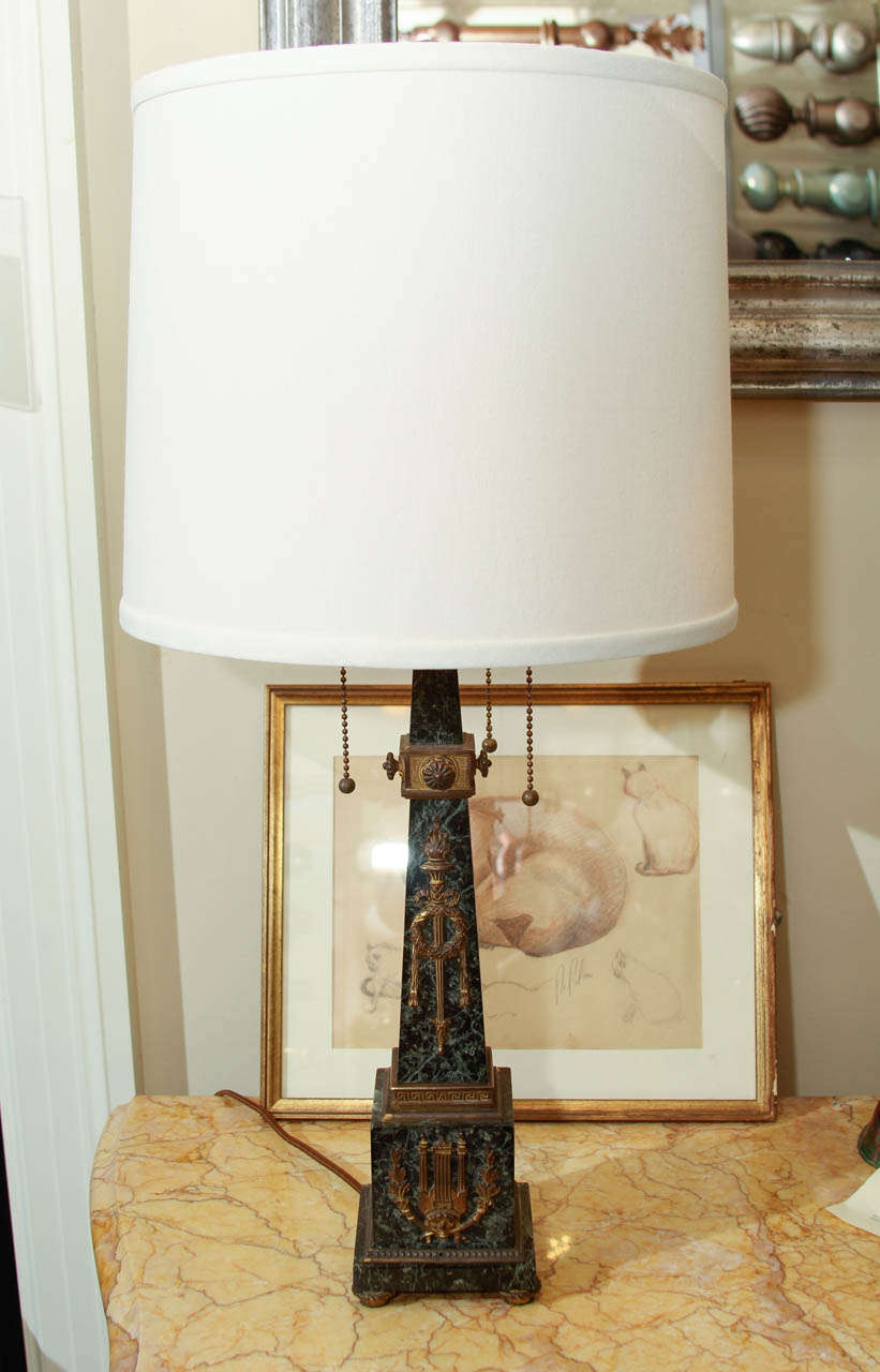 An early 20th century marble table lamp in the form of an obelisk with bronze detaining