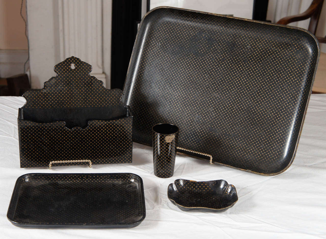 Five (5) pieces of Napoleon III papier mâché star motif table articles.
Wall pocket, two trays, card holder and cup. Black with gold star
lacquered pieces. Measurements are for the larger tray.