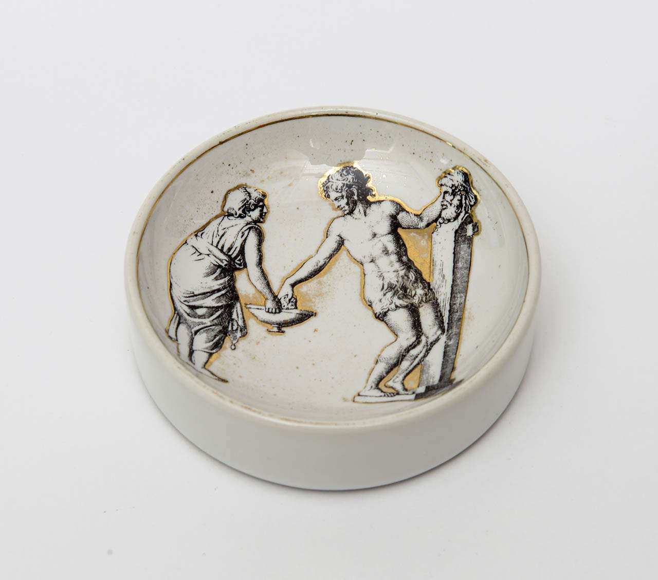 Classical and Roman would elicit the imagery on this signed lovely vintage Piero Fornasetti porcelain gilded bowl/ dish. It is hallmarked on the bottom.
It is Mid-Century Modern and classical Italian.

       