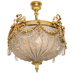 Un bellissimo lampadario in bronzo dorato con nastri e perline di E. F. A.