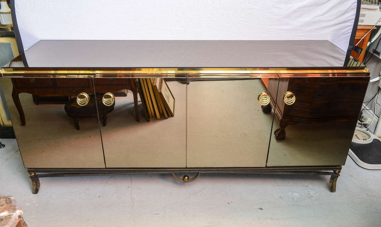 Stunning credenza mirrored all around except for the back.
Four doors with one center metal shelve.
Resting on a iron base with brass balls accent and brass pull.
