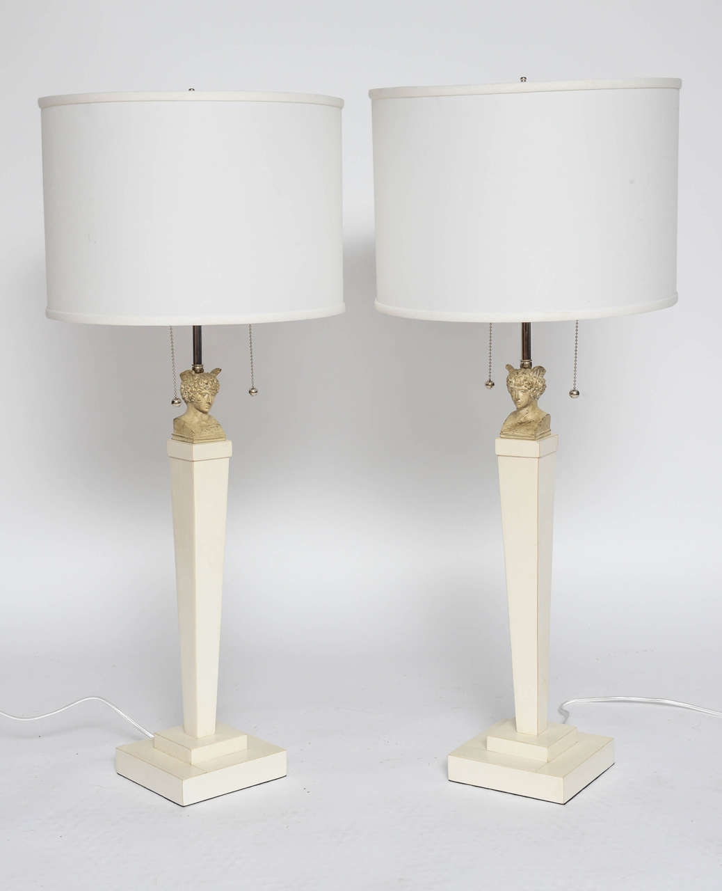 Clad in parchment and adorned with Hermès bust, these neoclassic style table lamps have double socket, newly wired and stand tall or elegant. Shades not included.
 