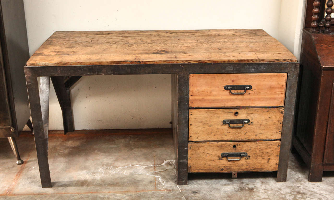 19th century desk in metal with wood top and drawers.