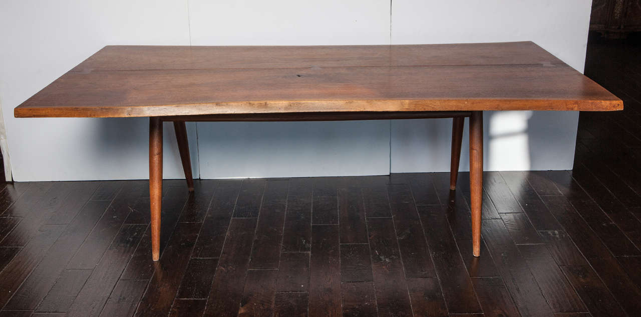 Free edge walnut dining table custom-made by George Nakashima. Top comprised of two walnut boards with two free edges and three butterfly keys. Four turned legs with two stretchers. Made in Pennsylvania, 1956. Proof of provenance provided.