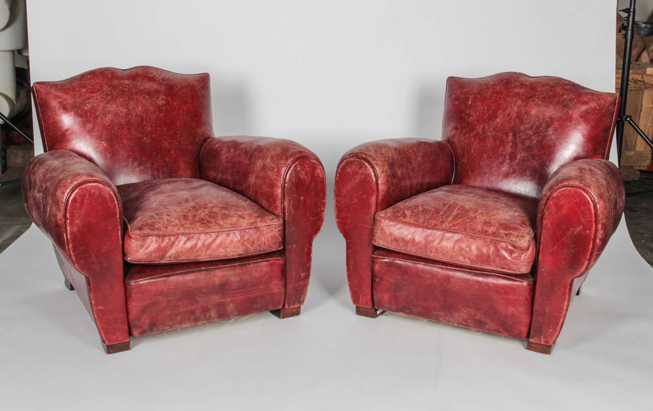 Cognac-colored leather armchairs with a mustache-back and rounded arms on wooden feet. Brass nailhead trim along back edges. Leather is aged and worn which adds to the overall character .

*Not available for sale or to ship in the state of