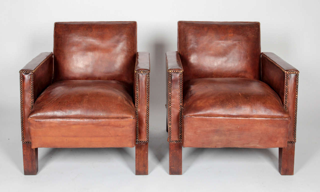 Pair of Art Deco club chairs with a brass nailhead trim. Structure of the chairs are Scandinavian-inspired with its modular style. Chair sits on four sturdy wooden chair legs.

*Not available for sale or to ship in the state of California.