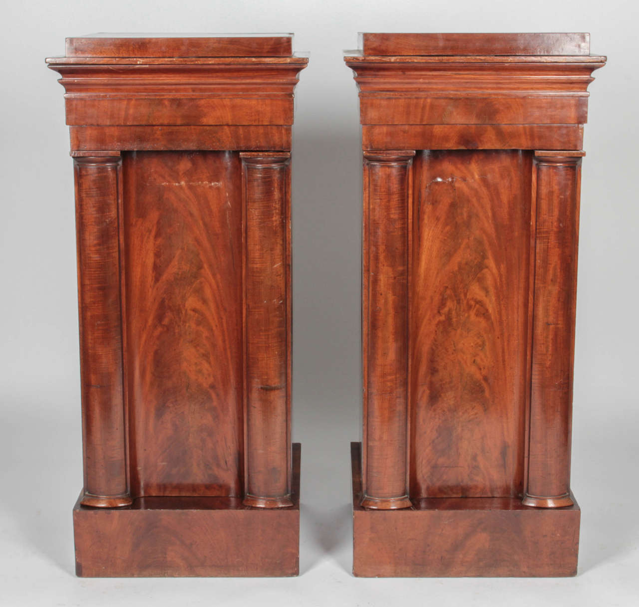 Wooden pedestal cabinets with worn felt lining on drawers. Pedestals mirror each other in outer appearance but differ on interior components. Both have a hidden top compartment lined with worn felt, accessed by pressing on a lever underneath the top