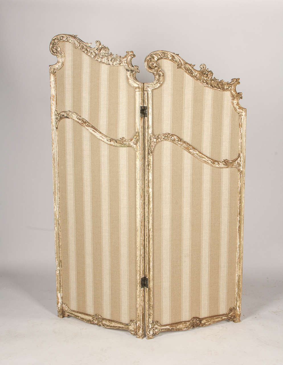This room divider has a beautiful patina throughout the carved wooden details of the frame. The four panels are connected as two sets of two - the hinge hardware connecting the middle section was removed.

Re-upholstered in Ralph Lauren fabric