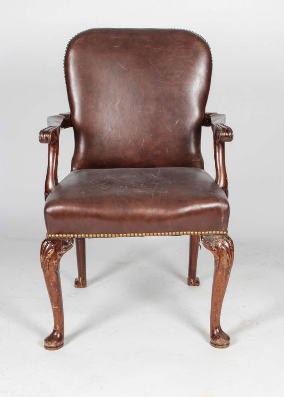 Queen Anne-style chair with cabriole front legs and rear splayed legs, all ending on pad feet. Carved shell design on front legs. Brass nailhead trim along edges. 

Not available for sale or to ship in the state of California.