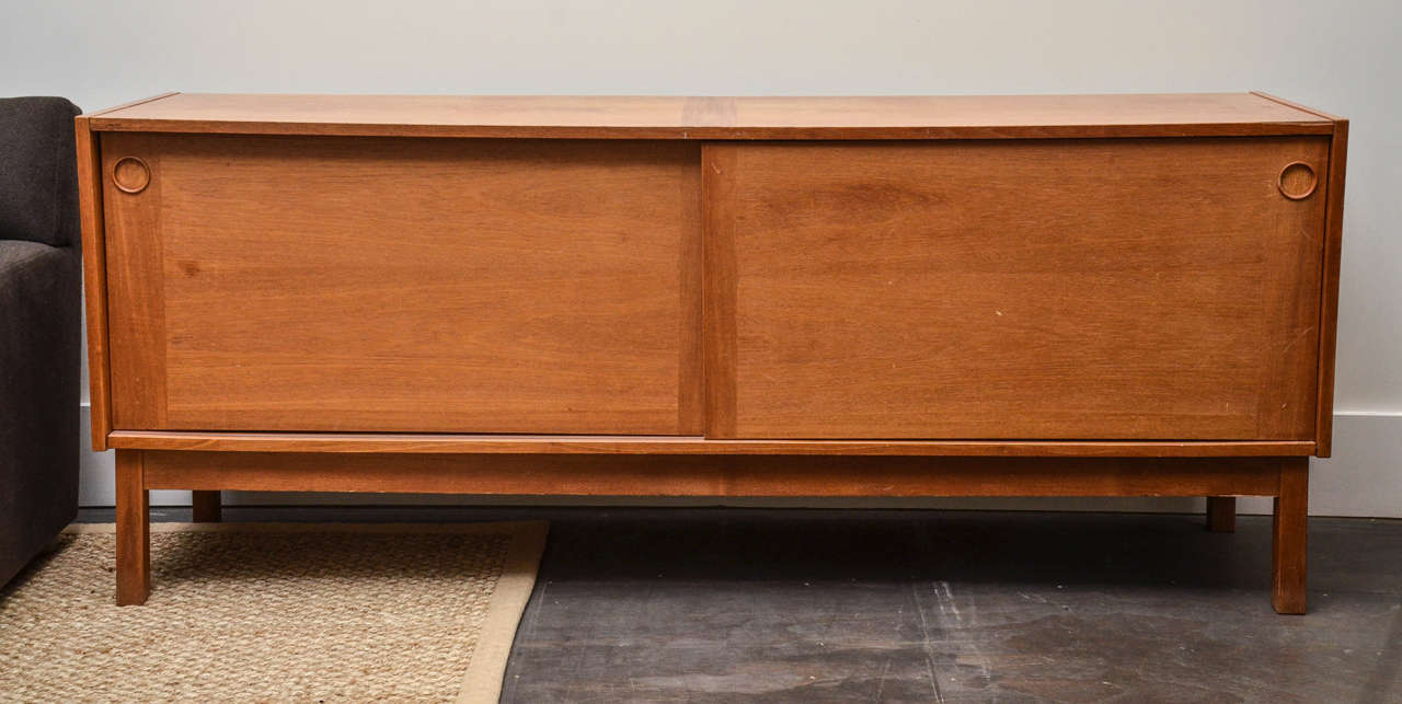 Danish modern teak credenza or sideboard in the manner of Børge Mogensen, with sliding doors and circular inlay handles.