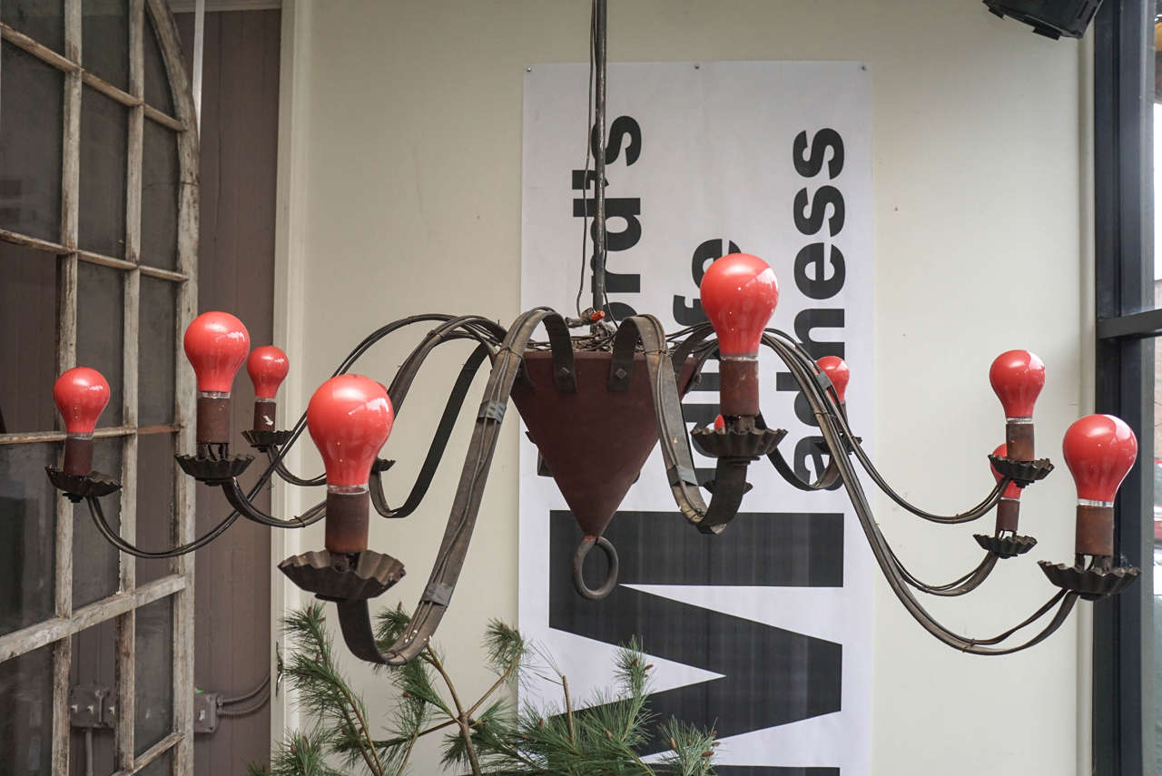 Two tin chandeliers with twelve alternating arms and attached to a center solid wood cone, from The Silver Nail Tavern in Norfolk, CT. Sold individually and need rewiring.