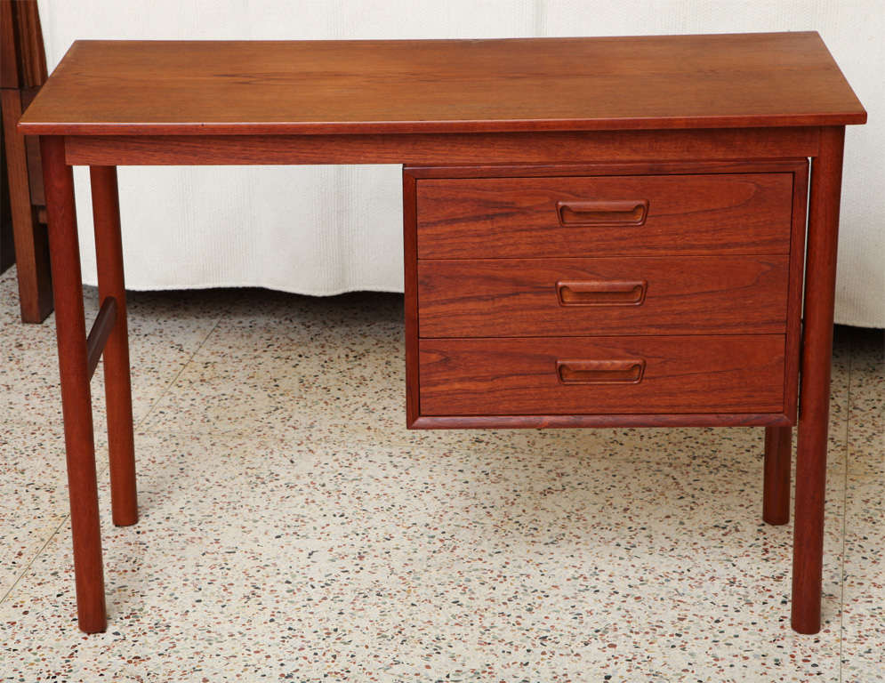 
Warm and beautifully figured teak highlights this compact Danish desk by Arne Vodder featuring a small footprint and profile while providing appropriate storage with a bank of three drawers. Finished all around, it can float in a room and is easily
